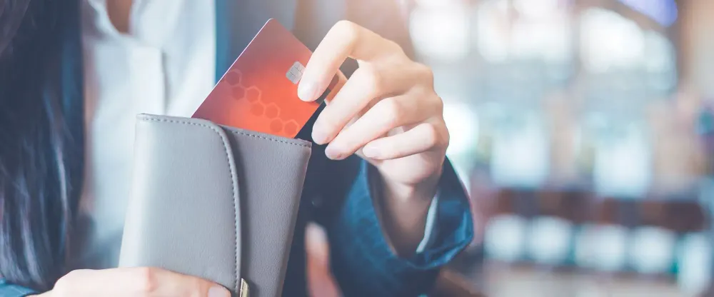 Close up of woman putting a credit card in her wallet